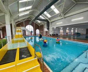 a swimming pool with children playing in the water at Lyons Robin Hood Caravan in Rhyl-5 min walk to Beach ,FREE Wi-Fi and FREE parking for 4 cars, sleeps up to 8 people-3 bedrooms in Rhyl