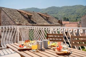 a wooden table with food and drinks on a balcony at Pharos Sunset - Stari Grad Center in Stari Grad