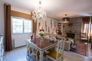 ein Esszimmer und ein Wohnzimmer mit Tisch und Stühlen in der Unterkunft Preciosa casa rural in Manzanares el Real