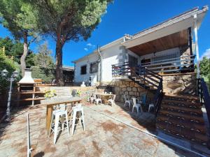 eine Terrasse mit Tisch und Stühlen und ein Gebäude in der Unterkunft Preciosa casa rural in Manzanares el Real