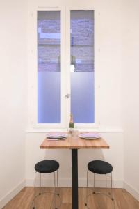 a table with two chairs and a bottle of wine at Appartement T1 bis L'enfilade in Albi
