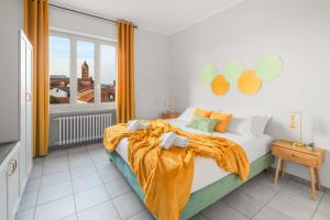 a bedroom with a bed with an orange blanket and a window at Panoramic Alba View, 2 Bedrooms with King Beds, Free Parking - La Dolce Vista in Alba