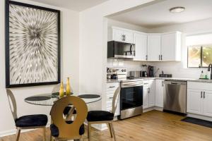 a kitchen with white cabinets and a table and chairs at Grey Sapphire Hideaway - 2BR 2BA w Arcade & Pool in Winston-Salem