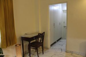 a room with a desk and a chair and a hallway at Deluxe Suite in Champa Villa in Gandhinagar