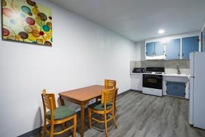a kitchen with a table and chairs and a refrigerator at Hitching Post Studios Inn in Santa Cruz