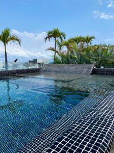 a swimming pool with blue water and palm trees at SOUL downtown 5 minutes away from the beach in Playa del Carmen