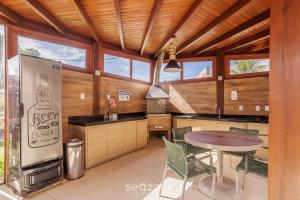 a large kitchen with a table and a refrigerator at CPR - Apartamentos a 200m da praia com Piscina in Marau