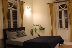 a bedroom with a bed and a plant in it at Super Deluxe Suite in Champa Villa in Gandhinagar +3 photos