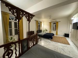 a living room with a bed and a balcony at Super Deluxe Suite in Champa Villa in Gandhinagar