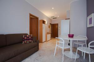 a living room with a couch and a table and chairs at Hotel Corso Alaxi Hotels in Alassio