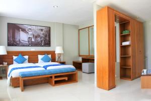 a bedroom with a large bed with blue pillows at Bakung Ubud Resort and Villa in Ubud