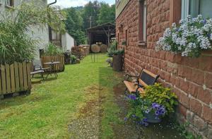 a garden with a bench and flowers next to a building at Ferienwohnung im Erdgeschoss direkt am Rad- und Spazierweg in Silz