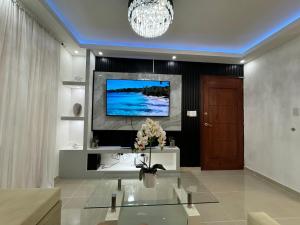 Una sala de estar con un televisor en la pared. en Casa las América, en La Cana 12 fotos más