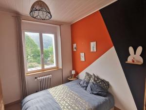 a bedroom with an orange accent wall and a bed at Vespa Casa in Cherbourg en Cotentin