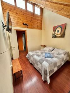 a bedroom with a bed in a room with wooden ceilings at DEPARTAMENTOS CLIMENT in Osorno