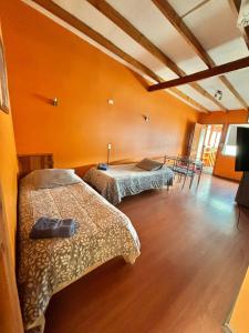 two beds in a room with orange walls at DEPARTAMENTOS CLIMENT in Osorno +91 photos