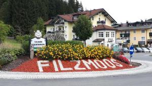 a sign in the middle of a street with flowers at Hotel Bergglück in Filzmoos