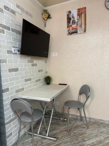 a table with two chairs and a tv on a wall at Апартаменти Dvoryanskay in Odesa +12 photos