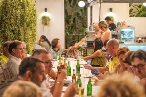 a group of people sitting at a table with drinks at Green Gallery Beach Boutique Hotel in Hua Hin