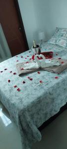 a bed with red rose petals on it at casa confortável piscina privativa in Camaçari +51 photos