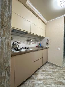 a kitchen with white cabinets and a stove at Апартаменти Dvoryanskay in Odesa
