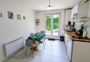 a kitchen with a table and chairs and a window at T2 calme 5 min gare, centre, parking gratuit in Dax