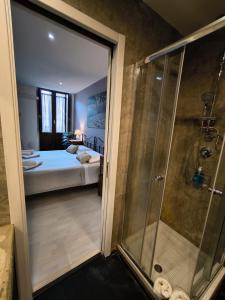 Un baño con ducha y un dormitorio con cama. en Bellini House, en Catania