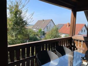 a table and chairs on a balcony with a view at Appartio - Ferienwohnung "Dorfblick" Dachgeschoss - 6 Personen - Netflix - Waschmaschine in Hofheim in Unterfranken