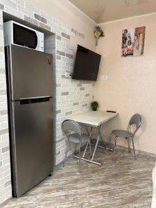 a kitchen with a table and a refrigerator in a room at Апартаменти Dvoryanskay in Odesa