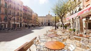 an empty street with tables and chairs on a city street at Plaça De La Font in Tarragona