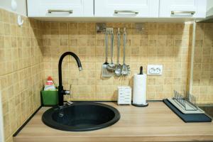 a kitchen counter with a black sink and utensils at Apartman Centar&Privatno garažno mesto in Požarevac +74 photos