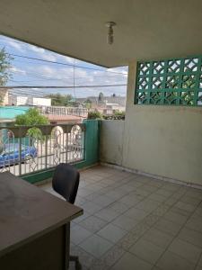 a room with a table and a chair on a balcony at hacienda los tulipanes in Monterrey