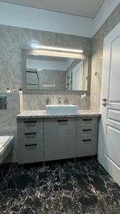 a bathroom with a sink and a mirror at SeaView Deluxe Double Studio - Beachfront Resort in Mamaia Nord