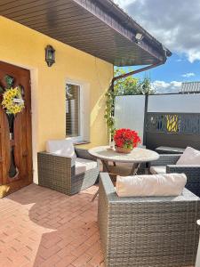 an outdoor patio with wicker chairs and a table at Agroturystyka Parlińskie Wody I in Parlino