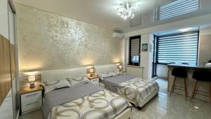 a bedroom with two beds and a desk and a sink at SeaView Deluxe Double Studio - Beachfront Resort in Mamaia Nord +32 photos