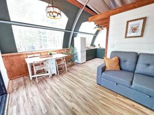 a living room with a blue couch and a table at Sunken Escapes Glamping Unit #1 in New Minas