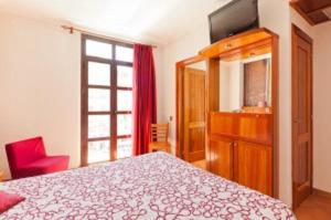 a bedroom with a bed and a tv and a window at Plaça De La Font in Tarragona