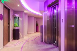 a hallway with purple walls and a fish tank at Mercure Toulouse Sud in Toulouse