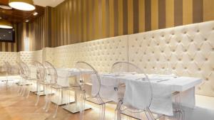 a row of white tables and chairs in a room at Plaça De La Font in Tarragona