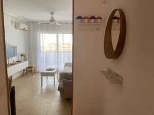 a living room with a couch and a mirror on a wall at Edificio TORREMAR vistas al mar, orientación norte, Wifi y Smart-TV in Oropesa del Mar