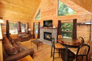 a living room with a fireplace in a log cabin at Thunder Bear Hideaway Roar Into Relaxation in Pigeon Forge