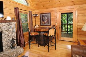 a dining room with a table and chairs in a cabin at Thunder Bear Hideaway Roar Into Relaxation in Pigeon Forge