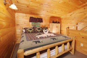 a bedroom with a bed in a log cabin at Thunder Bear Hideaway Roar Into Relaxation in Pigeon Forge