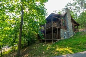 a log cabin in the woods with a balcony at Thunder Bear Hideaway Roar Into Relaxation in Pigeon Forge