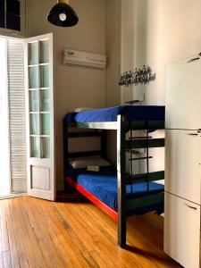 a room with two bunk beds and a refrigerator at Hostel Alvear in Córdoba