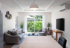 a living room with a large bed and two chairs at 2 Bed Coral Beach Condo Pool & Beach Access in Saint Peter