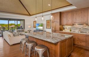 an open kitchen with a large island with bar stools at Mauna Lani Luxury Vacation Villas - CoralTree Residence Collection in Waikoloa