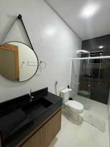 Un baño con lavabo, inodoro y espejo. en Loftpiranahas, en Piranhas