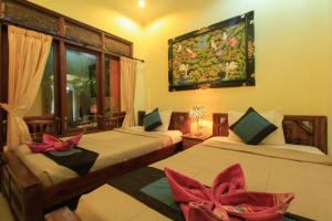 um quarto com 2 camas e uma janela em KT. Kuaya Home Stay em Ubud