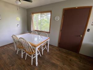 a dining room with a table and chairs and a window at Hickory Grove Hideaway in Galmey